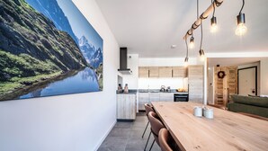 A modern kitchen with wooden cabinets, a large island, and pendant lighting.