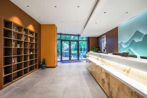 A reception area with a marble counter, a bookshelf, and a large window.