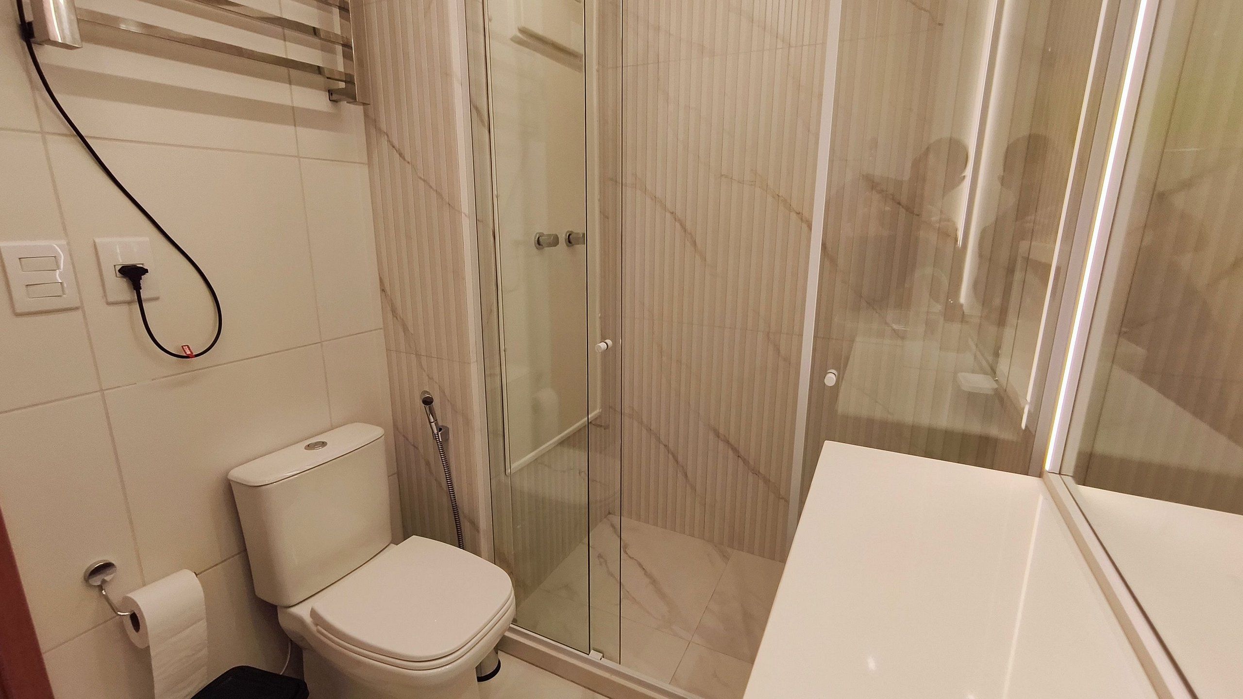 A bathroom with a toilet, a shower with a glass door, and a bathtub.