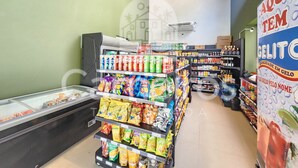 Un rayon de supermarché avec des étagères de produits d’épicerie, de collations et de boissons, une section réfrigérée et un congélateur.