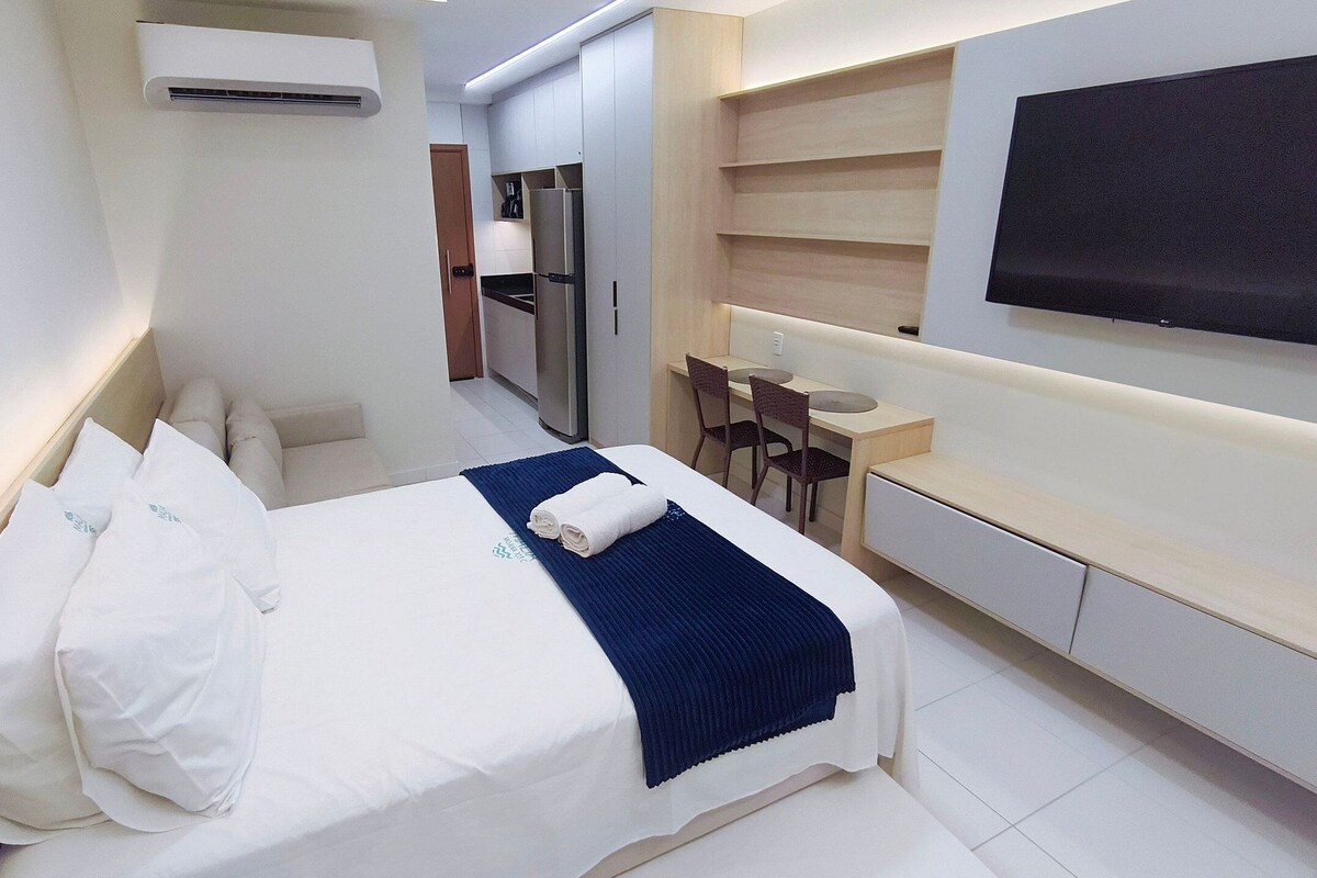 Une chambre d’hôtel équipée d’un lit, d’un bureau, d’une chaise, d’une télévision et d’un mini-bar.