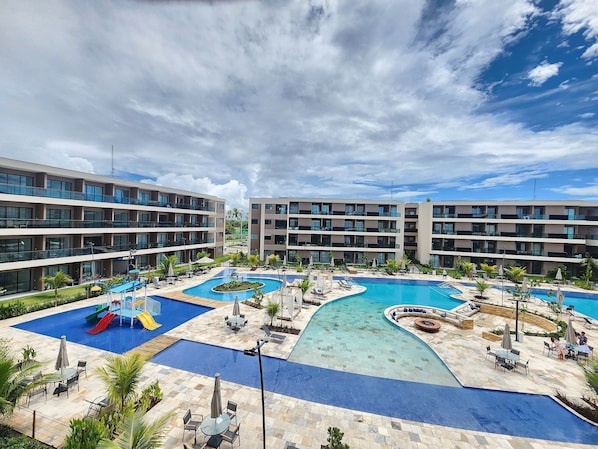 Un hôtel à étages, doté d’une piscine centrale et d’espaces extérieurs aménagés pour se détendre.