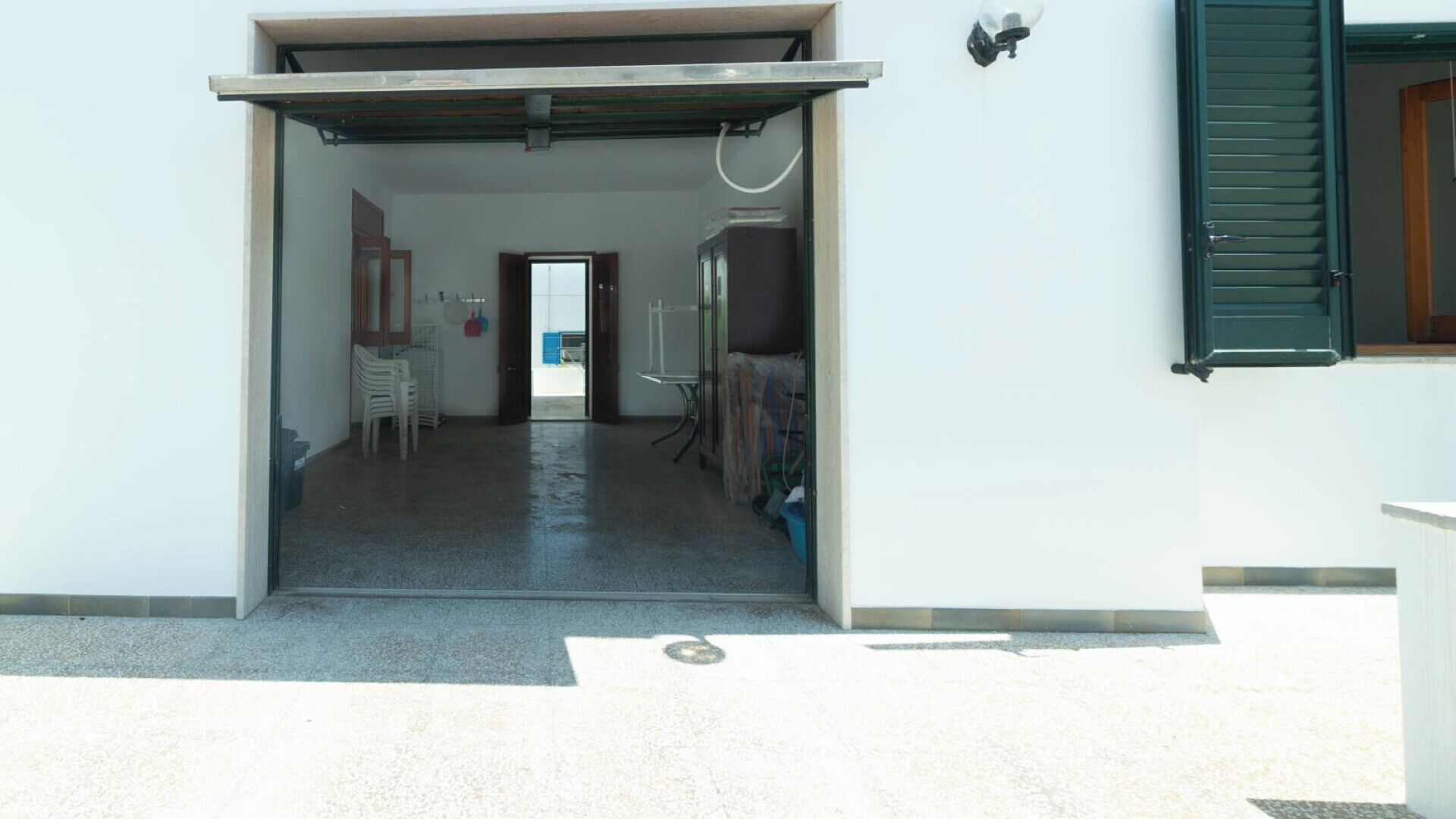 Un couloir menant à une pièce qui contient une porte, une chaise et une table.