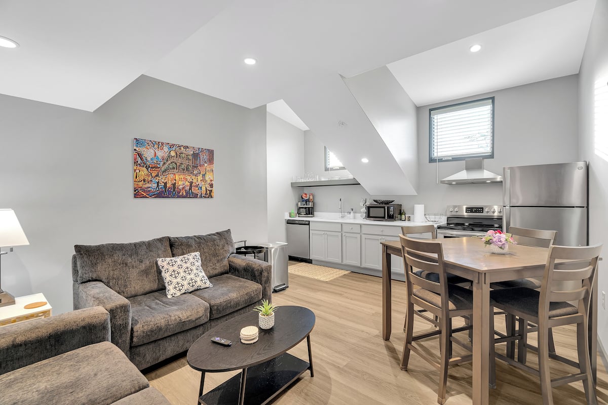 A modern apartment with a living room, dining area, and kitchen.