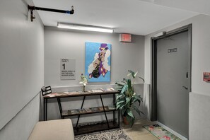 Zona de recepción con mostrador, planta y pintura en la pared.