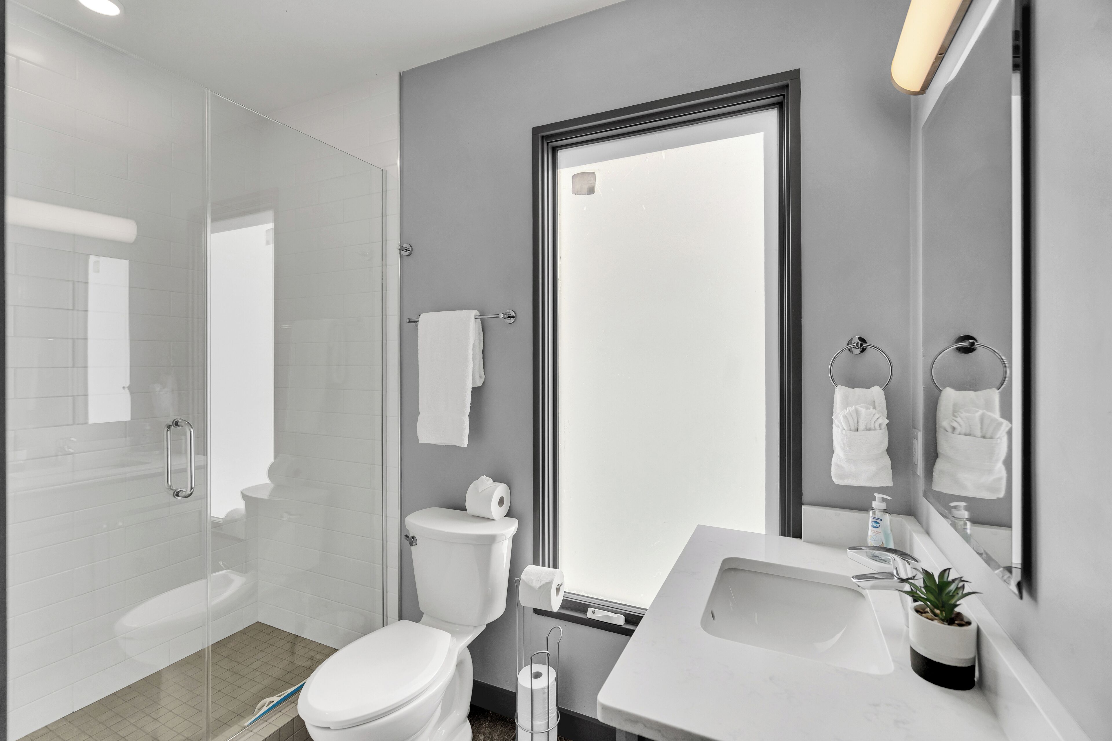 A modern bathroom with a toilet, sink, and shower.