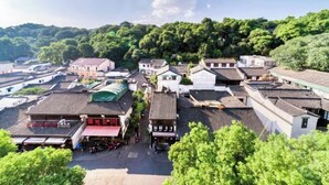 A traditional village with narrow streets and closely packed buildings, surrounded by lush greenery. - Guanhu Hotel (Hangzhou West Lake Hefang Street) (Hangzhou)