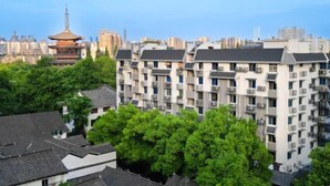 A multi-story residential building with a traditional pagoda in the background. - Guanhu Hotel (Hangzhou West Lake Hefang Street) (Hangzhou)