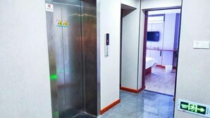 A hallway with an elevator, a sign indicating a no parking zone, and an exit sign. - Guanhu Hotel (Hangzhou West Lake Hefang Street) (Hangzhou)