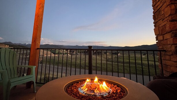 A fire pit with a view of a grassy landscape and mountains in the distance. - Spacious Mountain Retreat on Golf Course, near Rocky Mountain National Park (Granby)