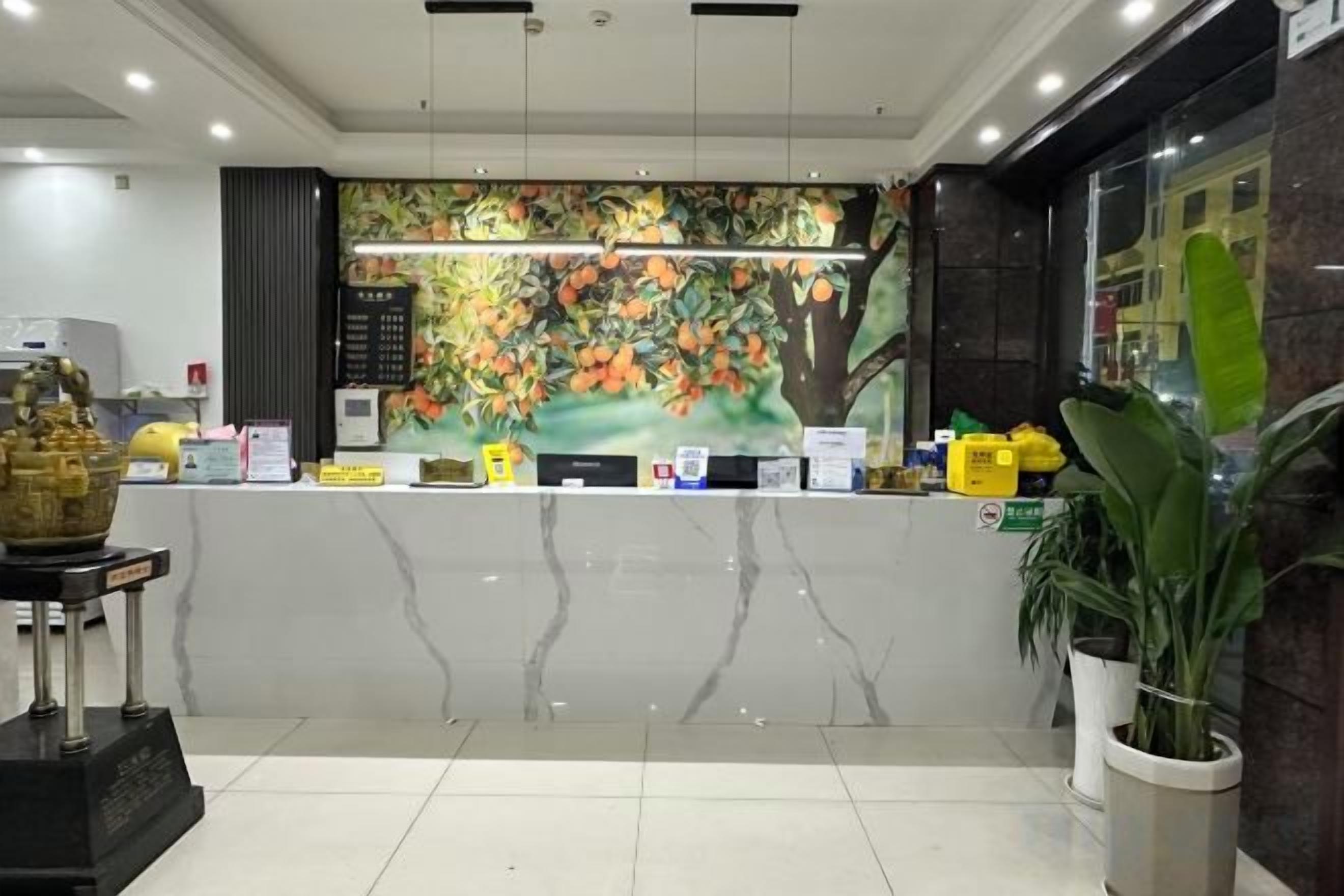 A reception area with a marble counter, a decorative wall mural, and a reception desk.