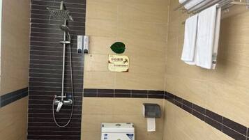 A bathroom with a shower, toilet, and towel rack.