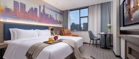 Quarto de hotel com uma cama grande, televisão, escrivaninha com cadeira e janela com vista para a cidade.