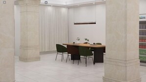 Un espace repas moderne avec une longue table, quatre chaises et un vase rempli de fleurs.