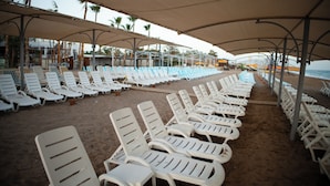 Rows of white lounge chairs under shaded umbrellas on a sandy beach. - Club Golf Hotel - All Inclusive (Manavgat)