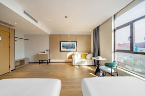 A modern hotel room with a large window, a sofa, a small table, and a chair. - Charlotte Boutique Hotel (Shanghai Zhoupu Wanda) (Shanghai)