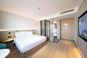 A modern hotel room with a large bed, bedside tables, a desk, and a TV mounted on the wall. - Charlotte Boutique Hotel (Shanghai Zhoupu Wanda) (Shanghai)