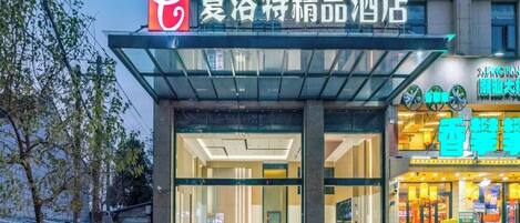A hotel entrance with a glass facade and a sign above it.