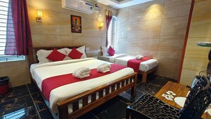 A hotel room with a large bed, a smaller bed, a wooden chair, a table, and a wall-mounted air conditioner. - PV Tower - Auro Beach (Vanur)
