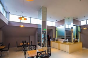 Un interior moderno con comedor, cocina y ventanas amplias.