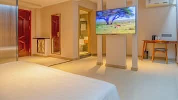 Een hotelkamer met een bed, een aan de muur bevestigde televisie, een bureau en een stoel.