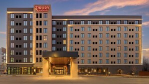 A Drury Plaza Hotel with a modern design, featuring multiple floors and a prominent entrance with glass doors.