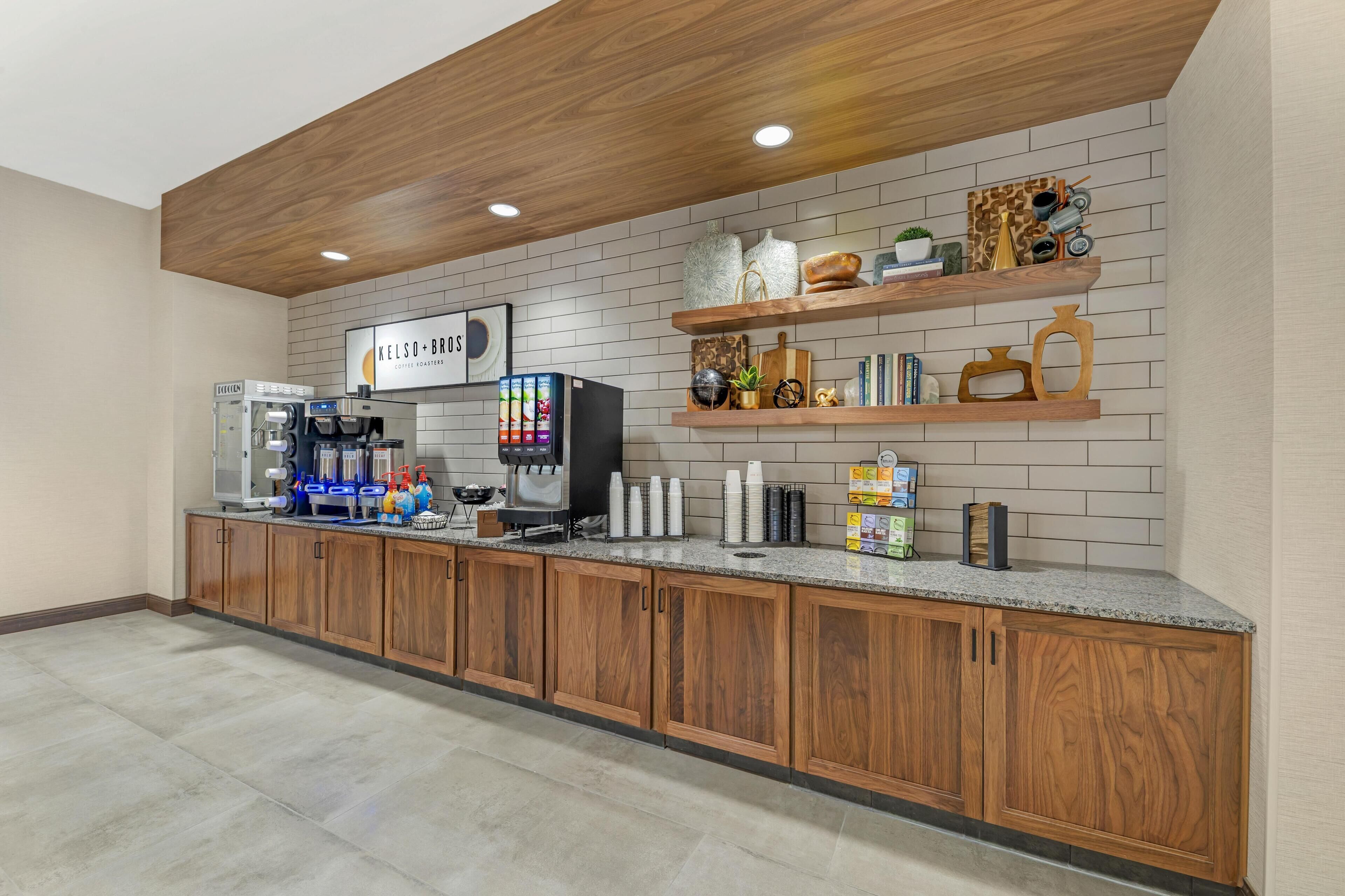 Eine moderne Kaffeestation mit einer beschrifteten Kennzeichnung, einer Kaffeemaschine und verschiedenen Kaffeetassen und -behältern.