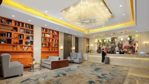A spacious lobby with a large chandelier, wooden bookshelves, a reception desk, and a seating area. - Vienna Classic Hotel (Kuanzhai Alley Luomashi Subway Station) (Chengdu)