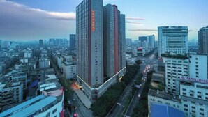 A high-rise building with a prominent vertical red stripe and a sign with Chinese characters. - Vienna Classic Hotel (Kuanzhai Alley Luomashi Subway Station) (Chengdu)