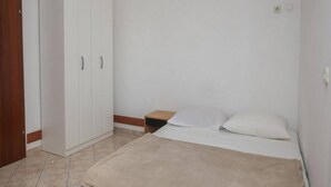 Une chambre à coucher avec un lit, une armoire et une table de chevet.