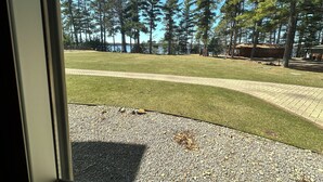 A view of a grassy area with trees and a building in the background. - Spirit of the Northwoods by Eagle Waters Resort (eagle river)