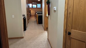 A hallway with carpeted floors, wooden doors, and a ceiling fan. - Spirit of the Northwoods by Eagle Waters Resort (eagle river)