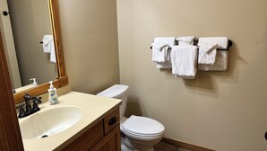 A bathroom with a sink, mirror, toilet, and towel rack. - Studio 111 By Eagle Waters Resort (eagle river)