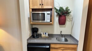 A compact kitchen with a microwave, coffee maker, and sink. - Studio 113 By Eagle Waters Resort (eagle river)