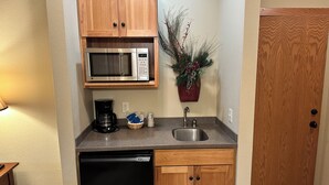 A compact kitchen with a microwave, coffee maker, sink, and dishwasher. - Studio 115 By Eagle Waters Resort (eagle river)