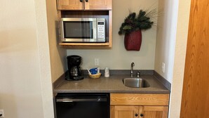 A compact kitchen with a microwave, coffee maker, sink, and dishwasher. - CONDO 107 by Eagle Waters Resort (eagle river)