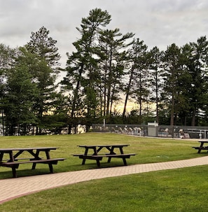 A park with picnic tables and a paved walkway.
