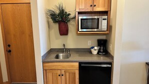 A compact kitchen with a stainless steel sink, a microwave, and a coffee maker. - Condo 206 W/ Garage by Eagle Waters Resort (eagle river)
