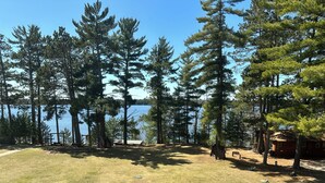 A campground with a lake view, surrounded by tall pine trees. - CONDO 301 by Eagle Waters Resort (eagle river)