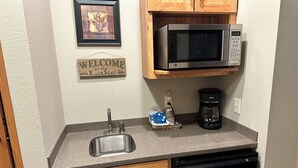 A kitchen with a stainless steel sink, a coffee maker, a microwave, and wooden cabinets. - Studio 311 by Eagle Waters Resort (Eagle river)