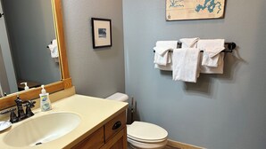 A bathroom with a sink, mirror, toilet, and towel rack. - Studio 311 by Eagle Waters Resort (Eagle river)