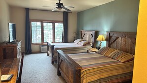 A bedroom with two wooden beds, a desk, a chair, a ceiling fan, and a window with curtains. - Studio 312 by Eagle Waters Resort (eagle river)