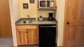 A compact kitchen with a stainless steel sink, a coffee maker, and a microwave. - Studio 312 by Eagle Waters Resort (eagle river)