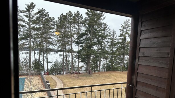 A balcony with a view of a wooded area and a lake. - Spirit of the Northwoods (eagle river)
