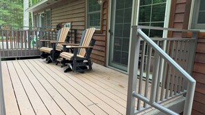 A wooden deck with outdoor furniture and a metal railing. - Cabin 16D by Eagle Waters Resort (eagle river)