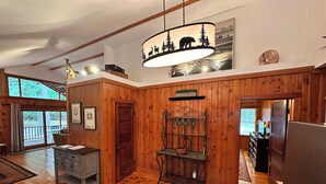 A wooden interior with a dining area, a kitchen, and a large window. - Cabin 3 by Eagle Waters Resort (eagle river)