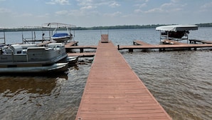 A wooden pier extending into calm water with boats docked at the end. - 2-2 4-Plex by Eagle Waters Resort (eagle river)