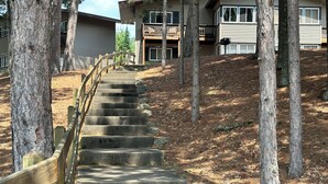 A wooden staircase leading to a building with a balcony. - 2-2 4-Plex by Eagle Waters Resort (eagle river)