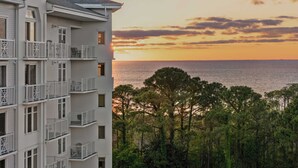 A multi-story building with balconies overlooking a coastal area during sunset. - Studio Condo in Luxe Sandestin Resort w/ Balcony, Pool, + Walk to Baytowne Wharf (Miramar Beach)