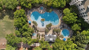 An aerial view of a resort with multiple swimming pools surrounded by lush greenery and palm trees. - Studio Condo in Luxe Sandestin Resort w/ Balcony, Pool, + Walk to Baytowne Wharf (Miramar Beach)